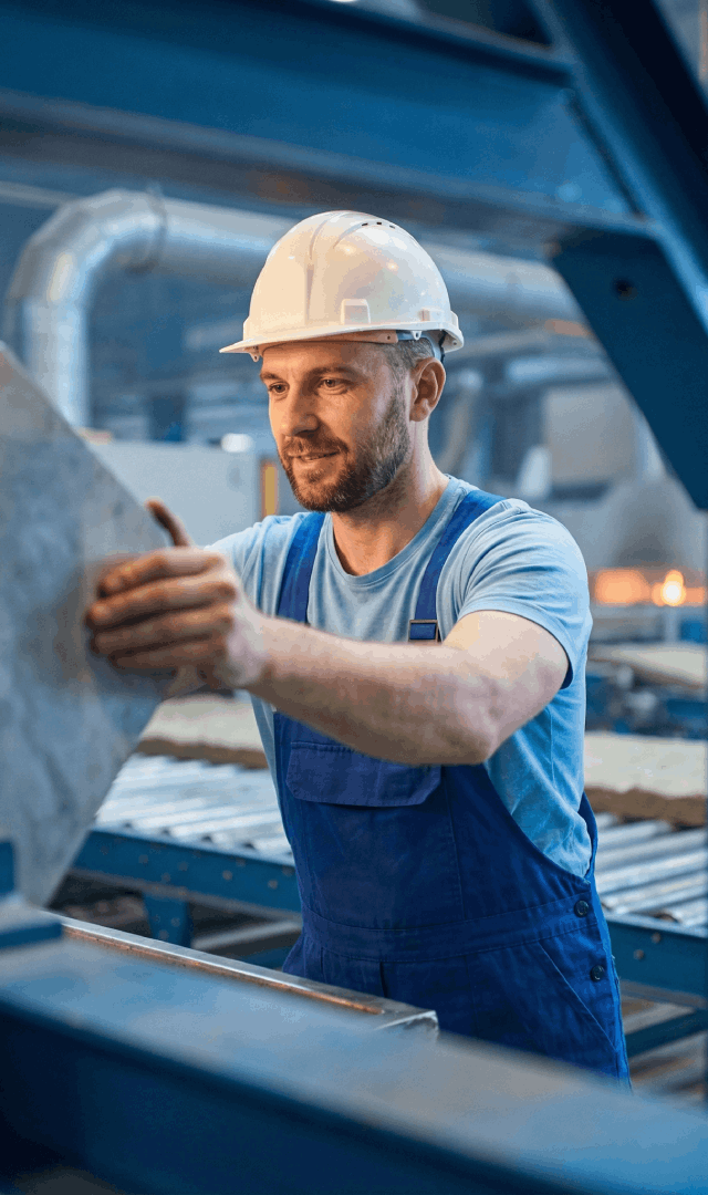 kingspan_recruiting_bild Produktionsmitarbeiter mit Schutzhelm arbeitet an moderner Fertigungsanlage bei Kingspan Ronneburg